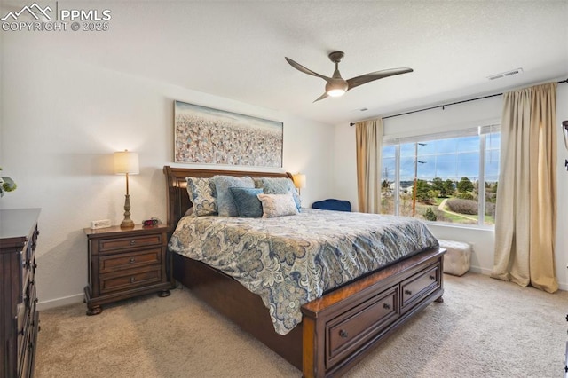 bedroom featuring light colored carpet, baseboards, visible vents, and a ceiling fan