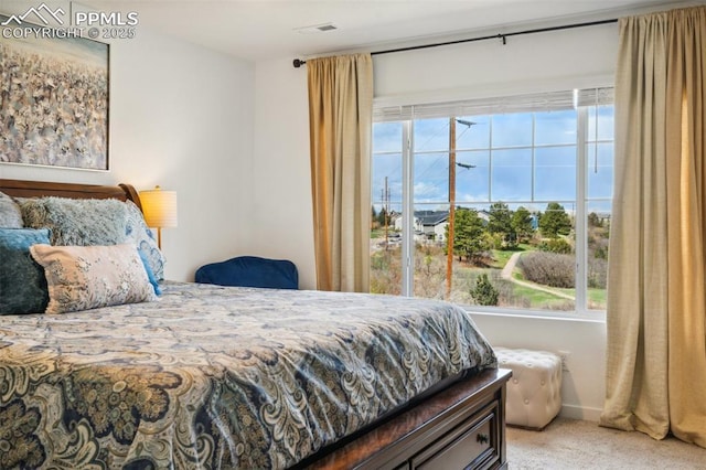 bedroom with visible vents and light carpet