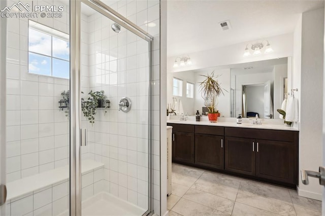 full bathroom featuring plenty of natural light, a shower stall, and visible vents