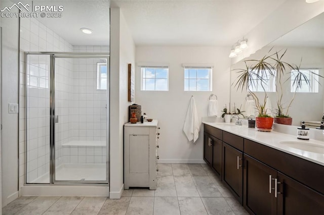 full bathroom featuring double vanity, baseboards, a shower stall, and a sink