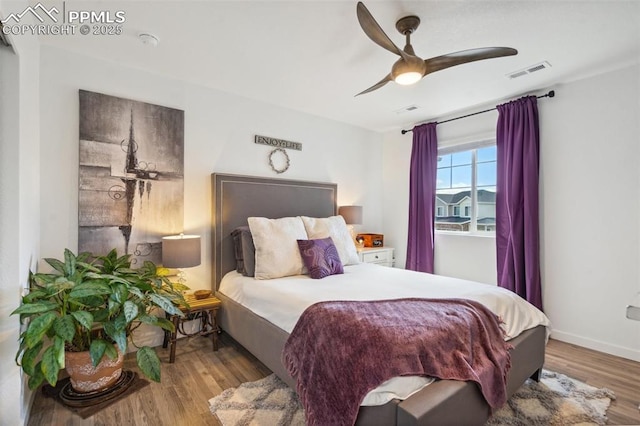 bedroom with a ceiling fan, wood finished floors, and visible vents