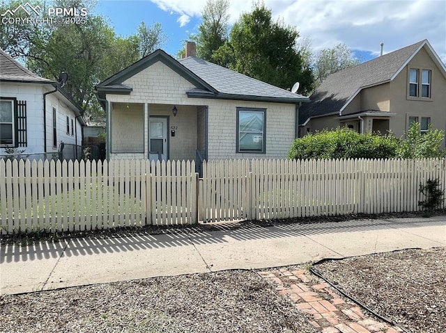 522 N Spruce St, Colorado Springs, CO 80905 - view of front of home featuring a porch, a chimney, and a fenced front yard