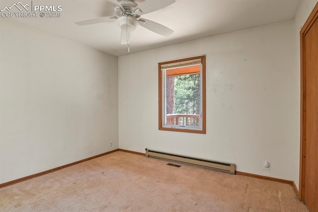 carpeted spare room featuring baseboard heating, ceiling fan, baseboards, and visible vents