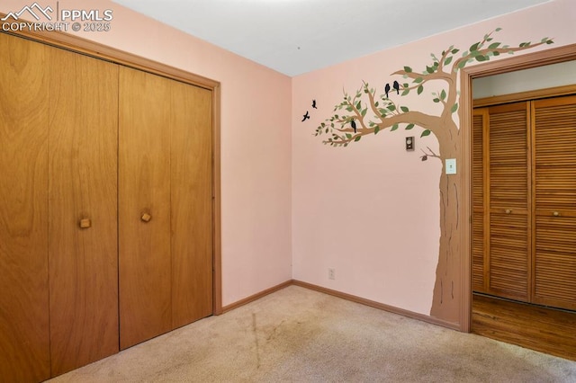 unfurnished bedroom featuring a closet, baseboards, and light carpet