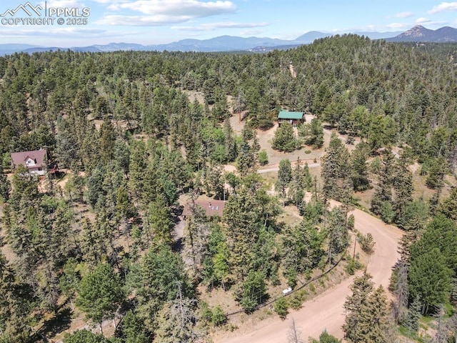 bird's eye view featuring a wooded view and a mountain view
