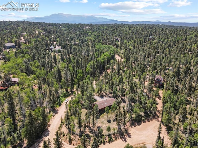 birds eye view of property featuring a wooded view and a mountain view