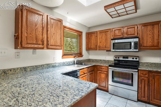 kitchen featuring light tile patterned floors, brown cabinetry, light stone counters, a sink, and stainless steel appliances