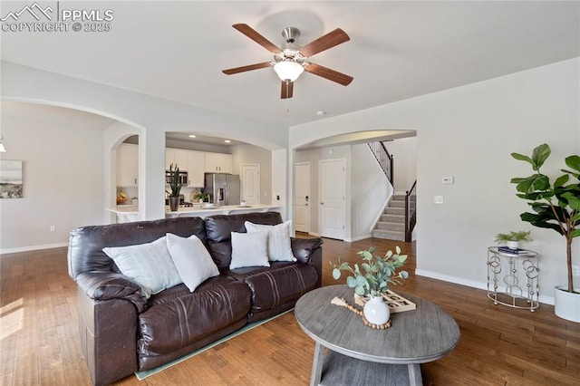 12529 Culebra Peak Dr, Peyton, CO 80831 - living area with arched walkways, baseboards, wood finished floors, ceiling fan, and stairway