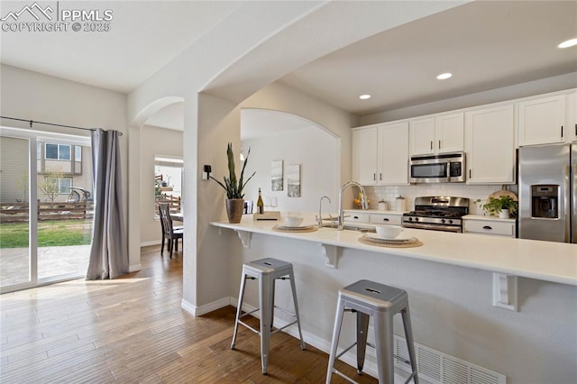 12529 Culebra Peak Dr, Peyton, CO 80831 - kitchen featuring recessed lighting, a breakfast bar, a sink, tasteful backsplash, and appliances with stainless steel finishes