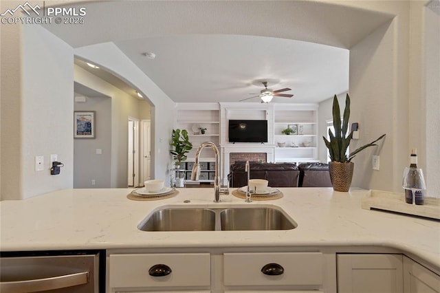 12529 Culebra Peak Dr, Peyton, CO 80831 - kitchen featuring white cabinets, a ceiling fan, a sink, light stone countertops, and open floor plan