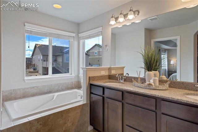 12529 Culebra Peak Dr, Peyton, CO 80831 - ensuite bathroom with ensuite bath, double vanity, visible vents, and a sink