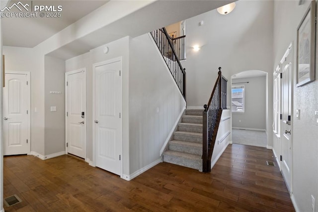12529 Culebra Peak Dr, Peyton, CO 80831 - entrance foyer with arched walkways, baseboards, visible vents, stairway, and hardwood / wood-style floors