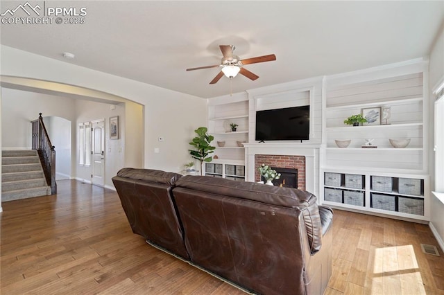 12529 Culebra Peak Dr, Peyton, CO 80831 - living area with ceiling fan, wood finished floors, stairs, and a fireplace