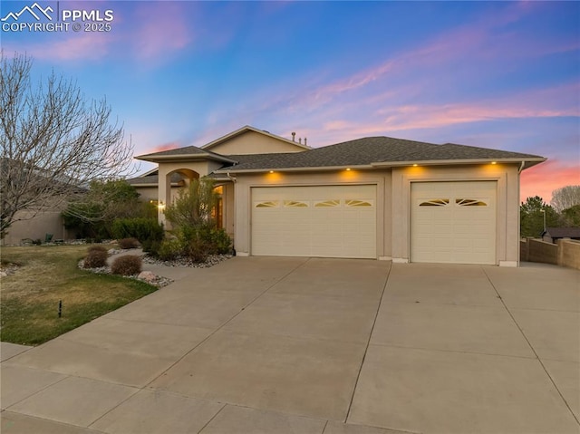 18 Redondo Ln, Pueblo, CO 81005 - view of front facade with an attached garage, driveway, and stucco siding