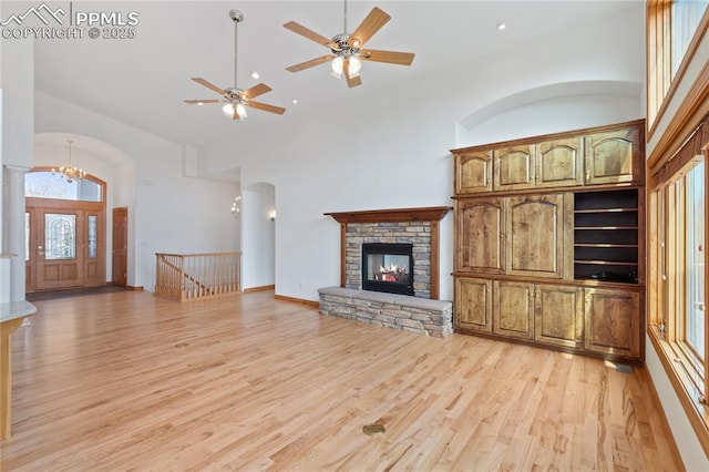 18 Redondo Ln, Pueblo, CO 81005 - unfurnished living room featuring a stone fireplace, recessed lighting, high vaulted ceiling, light wood finished floors, and ceiling fan with notable chandelier