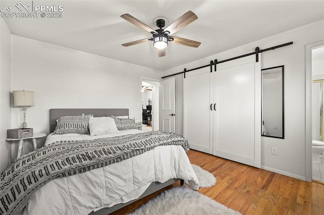 219 Fairfax St, Colorado Springs, CO 80911 - bedroom featuring light wood finished floors, a barn door, baseboards, a ceiling fan, and ensuite bath