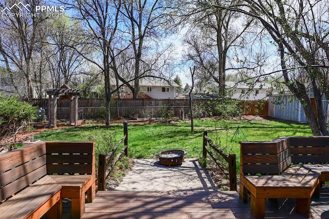 219 Fairfax St, Colorado Springs, CO 80911 - wooden terrace featuring a fenced backyard, an outdoor structure, an outdoor fire pit, and a lawn