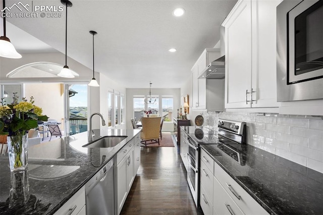 4225 New Santa Fe Trl, Colorado Springs, CO 80924 - kitchen featuring stainless steel appliances, a sink, wall chimney exhaust hood, dark wood-style floors, and white cabinetry