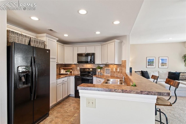 1530 Little Bear Creek Pt Unit 302, Colorado Springs, CO 80904 - kitchen featuring backsplash, visible vents, a sink, black appliances, and a peninsula