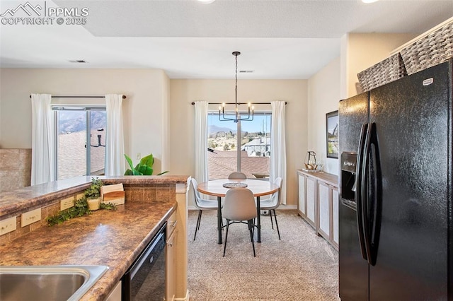 1530 Little Bear Creek Pt Unit 302, Colorado Springs, CO 80904 - kitchen with a notable chandelier, light carpet, a healthy amount of sunlight, and black appliances