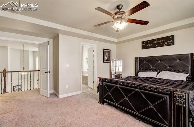 10585 Abrams Dr, Colorado Springs, CO 80925 - bedroom featuring baseboards, ensuite bath, a ceiling fan, a raised ceiling, and light colored carpet