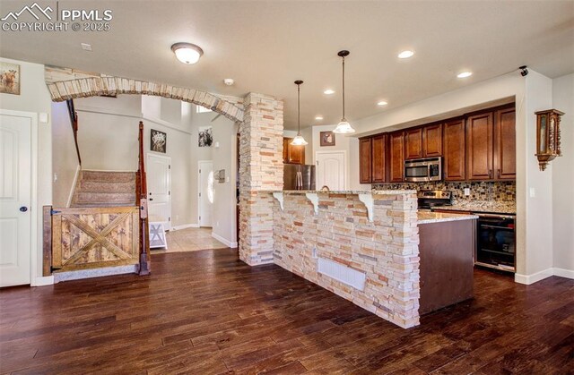 10585 Abrams Dr, Colorado Springs, CO 80925 - kitchen featuring a peninsula, dark wood-type flooring, a breakfast bar area, stainless steel appliances, and beverage cooler