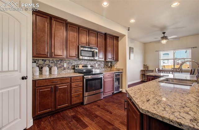 10585 Abrams Dr, Colorado Springs, CO 80925 - kitchen with appliances with stainless steel finishes, dark wood-style flooring, a sink, wine cooler, and backsplash