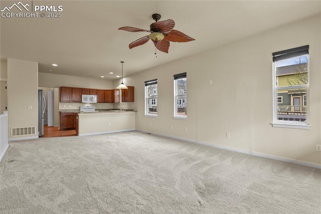 147 Celestine St, Colorado Springs, CO 80905 - unfurnished living room featuring light carpet, a ceiling fan, visible vents, and plenty of natural light