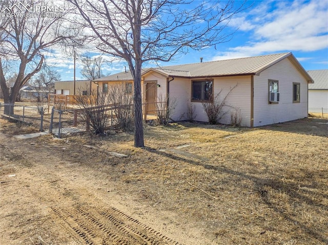 722 6th St, Hugo, CO 80821 - view of side of home featuring fence, metal roof, and cooling unit