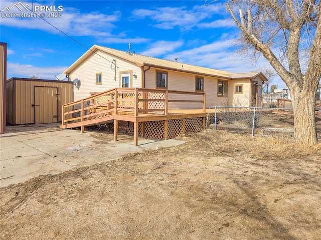 722 6th St, Hugo, CO 80821 - rear view of house with a storage unit, a wooden deck, fence, and an outdoor structure