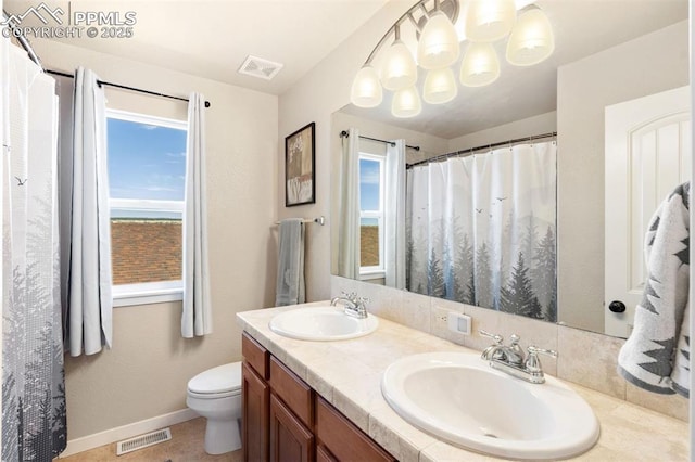 bathroom with visible vents, plenty of natural light, and a sink