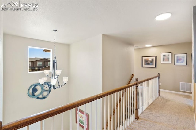 hallway featuring visible vents, an upstairs landing, an inviting chandelier, light carpet, and recessed lighting