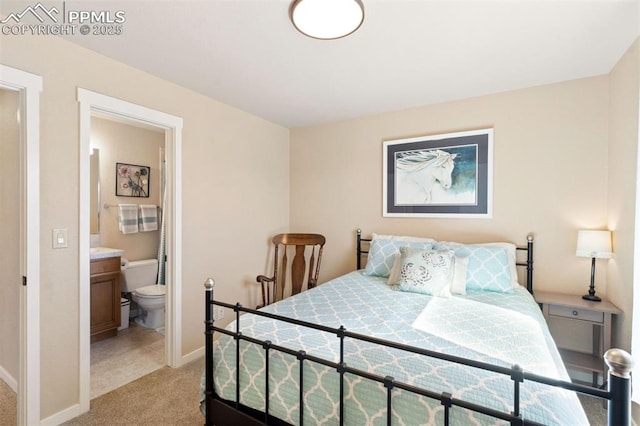 bedroom with connected bathroom, baseboards, and light carpet