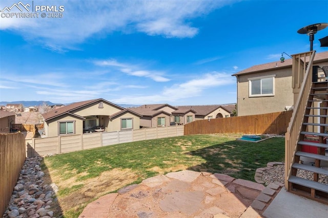 view of yard featuring stairs, a fenced backyard, and a residential view