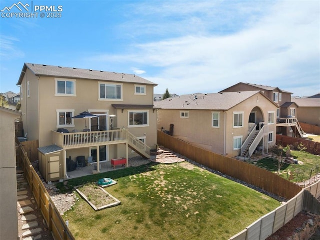 back of house with stairs, stucco siding, a deck, a fenced backyard, and a patio