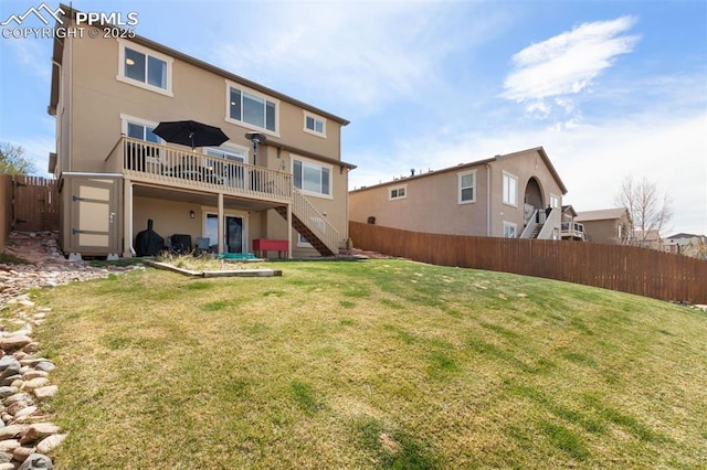 rear view of house featuring a wooden deck, a fenced backyard, stucco siding, stairs, and a yard