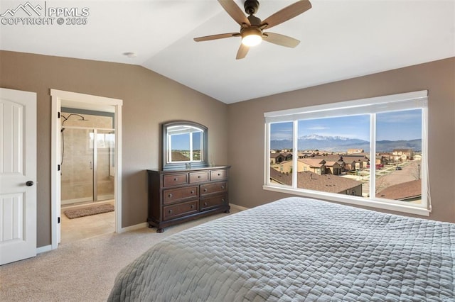 bedroom featuring lofted ceiling, baseboards, ensuite bathroom, light colored carpet, and a ceiling fan