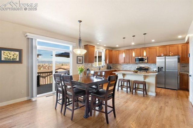 dining area featuring recessed lighting, baseboards, and light wood finished floors