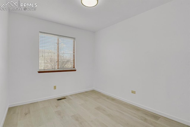 unfurnished room with baseboards, visible vents, and light wood-type flooring