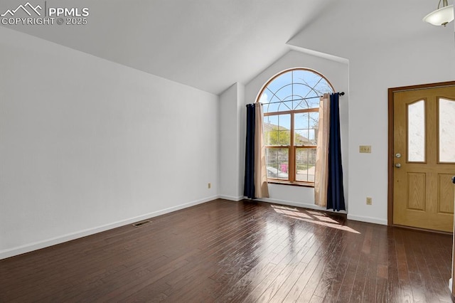 foyer featuring dark wood-type flooring, lofted ceiling, visible vents, and baseboards