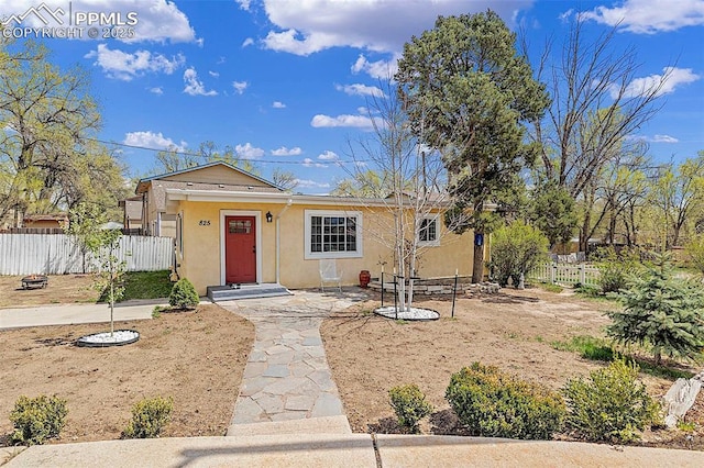 view of front of home featuring stucco siding and fence
