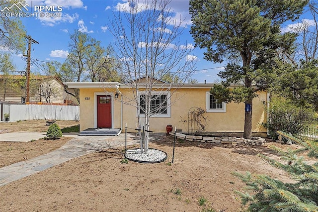 view of front of house featuring stucco siding and fence