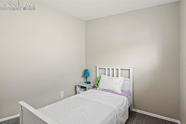 bedroom with dark carpet and baseboards