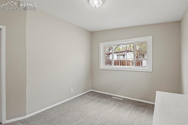 unfurnished room with carpet floors, visible vents, and baseboards