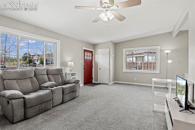 living area with baseboards, a ceiling fan, carpet flooring, and vaulted ceiling