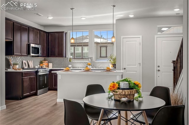 6375 Laud Pt, Colorado Springs, CO 80924 - kitchen with dark brown cabinetry, decorative backsplash, light countertops, and stainless steel appliances