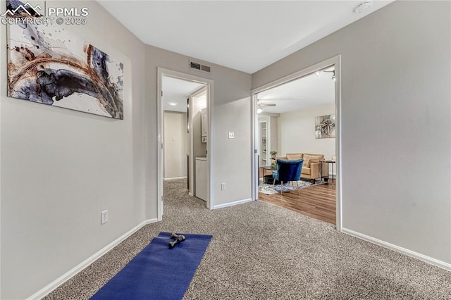 exercise area featuring visible vents, baseboards, carpet floors, and ceiling fan