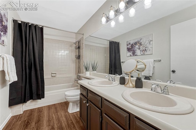 bathroom with shower / bath combo with shower curtain, a sink, wood finished floors, and toilet