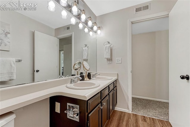 full bathroom featuring visible vents, a sink, and wood finished floors