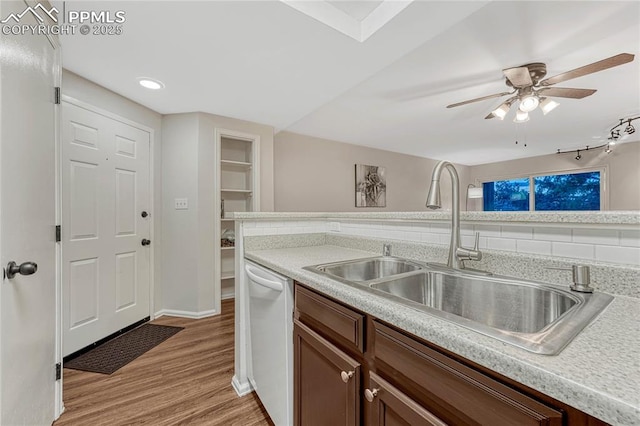 kitchen with white dishwasher, a sink, light countertops, a ceiling fan, and light wood-type flooring